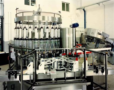 Impianto di riempimento automatico per bottiglie in un ambiente industriale.