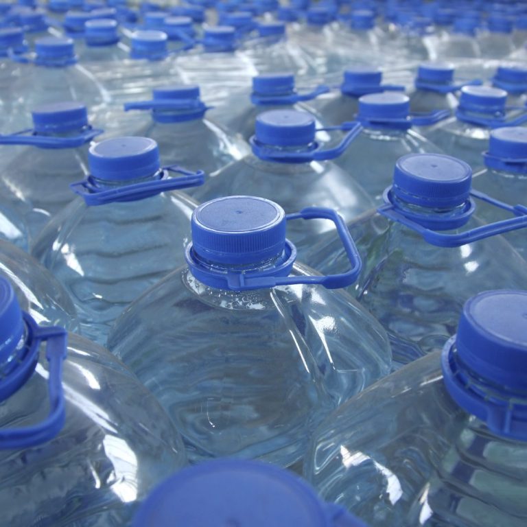 Bottiglie d'acqua con tappi blu disposte strettamente insieme.