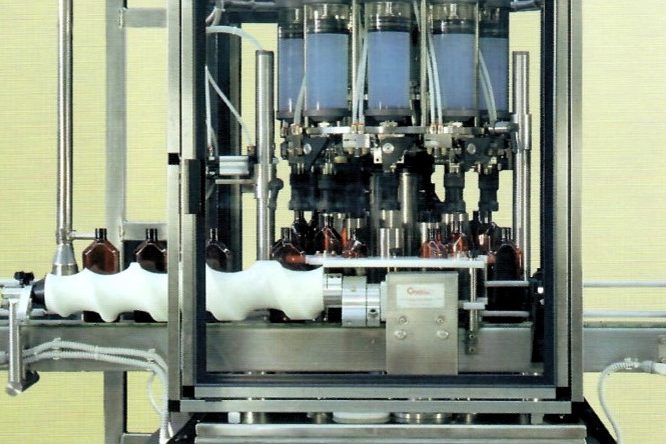 Macchina automatica per il riempimento di bottiglie in una linea di produzione.